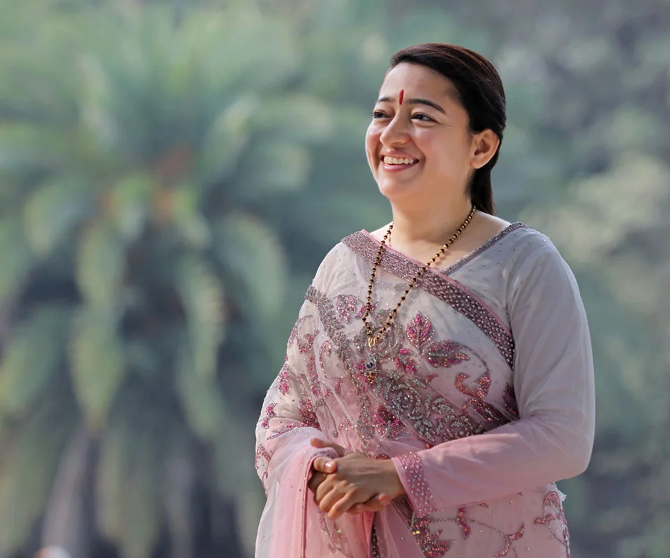 Meditation Guru Archna Didi smiling, wearing a pink saree